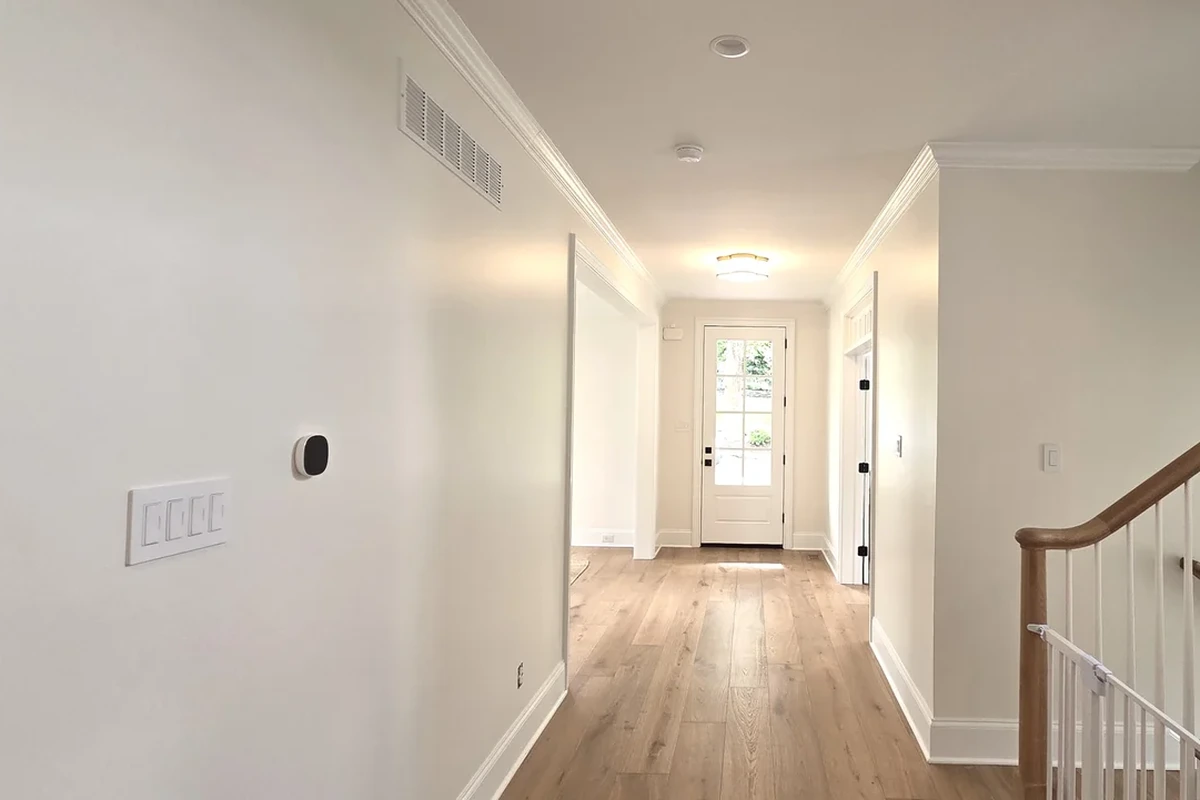 Smooth hallway wall with crown moulding and baseboard after prep and paint by Colour Craft Painting