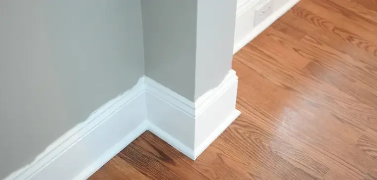 Crisp white baseboard against a blue wall