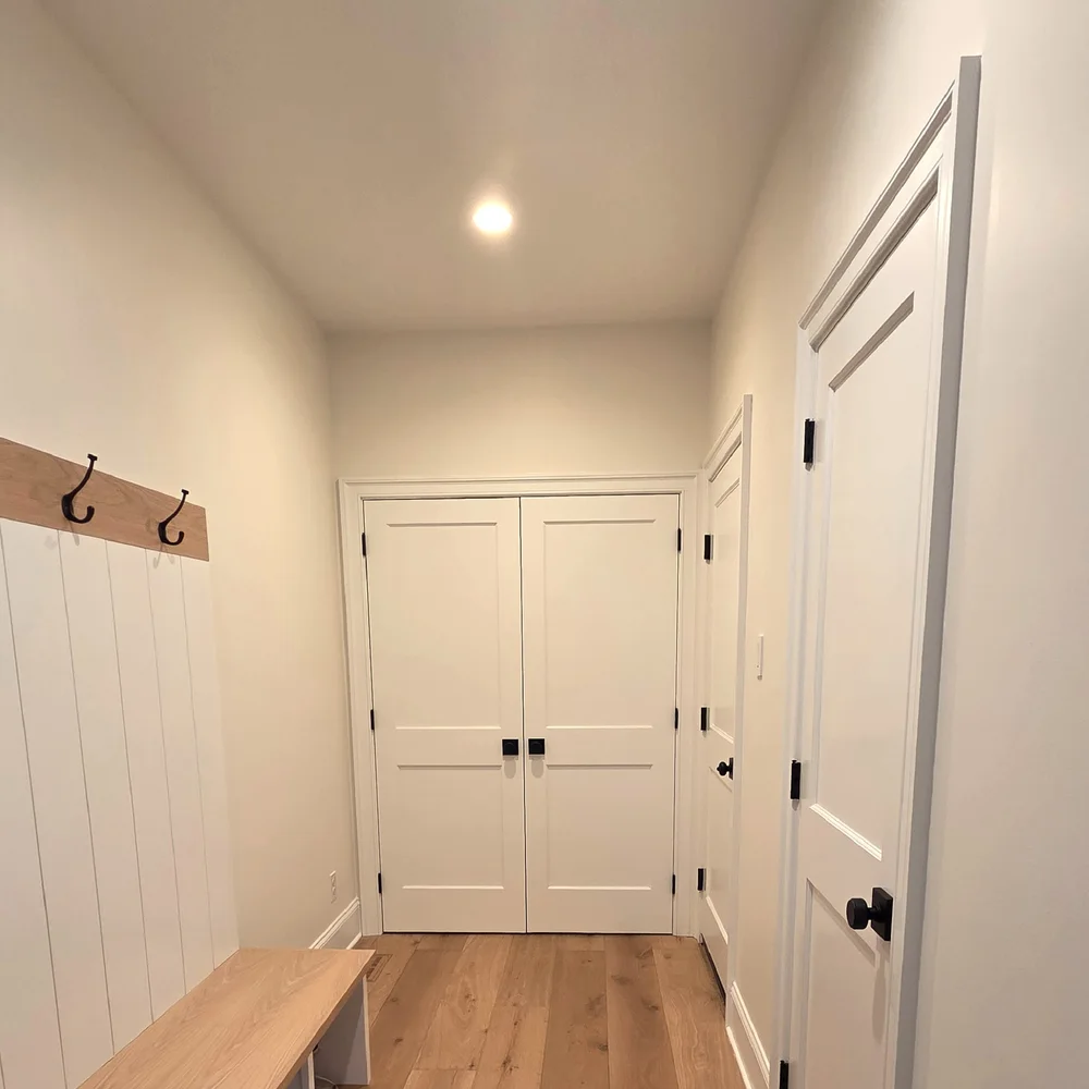 Mudroom with white walls, doors and built-in bench after an interior refresh by Colour Craft Painting