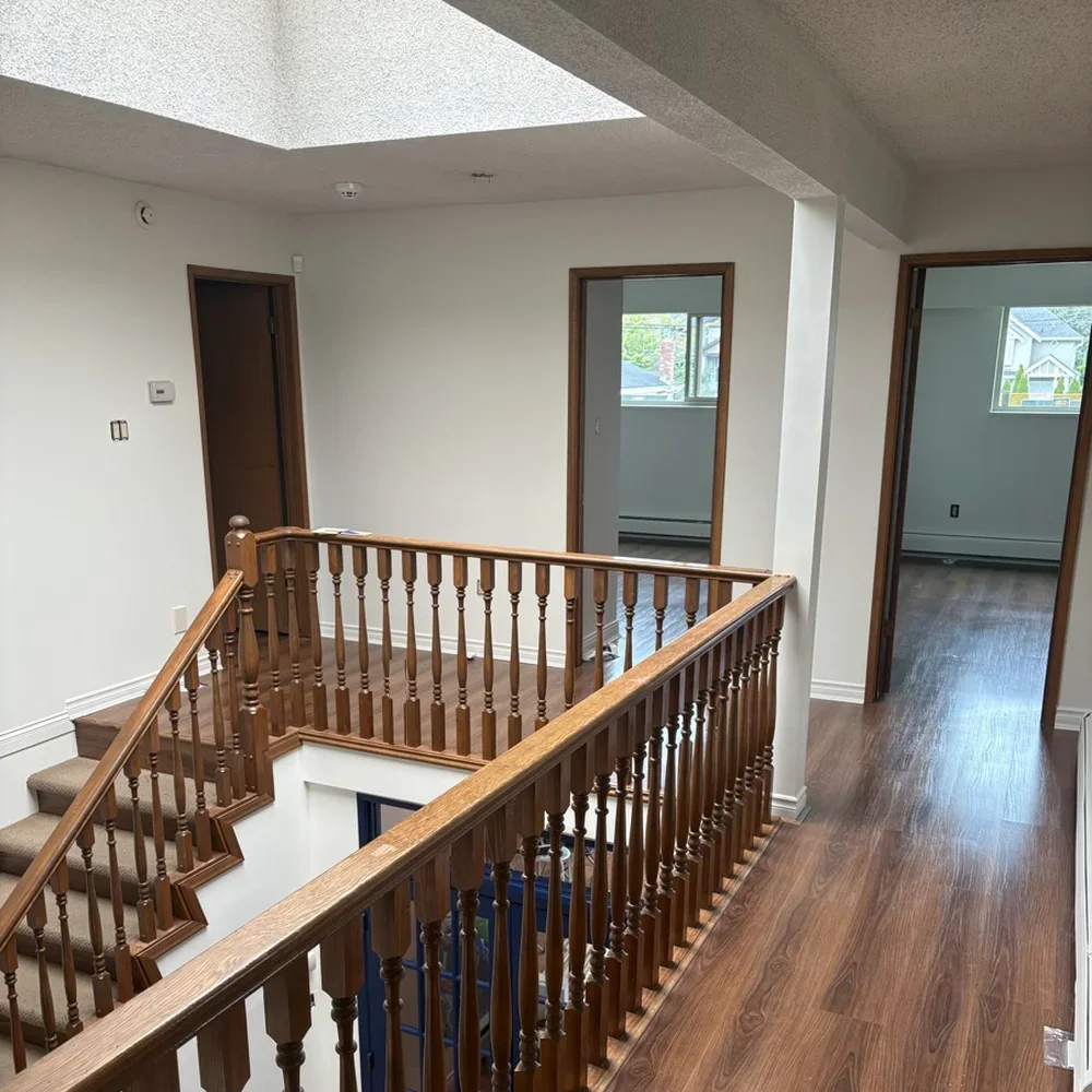 Upstairs landing with skylight and wood railing after a full interior repaint by Colour Craft Painting